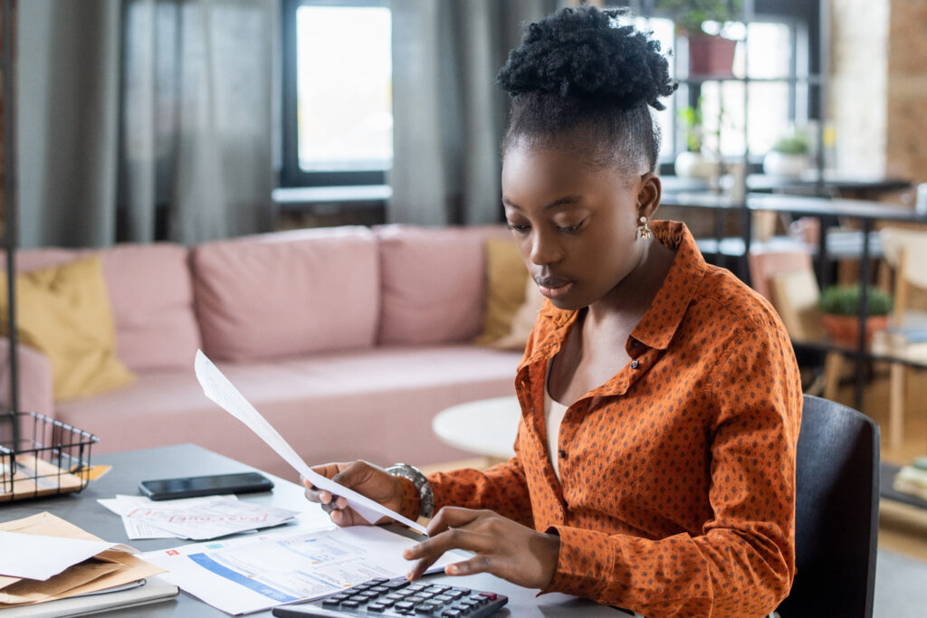 Young Black Woman Calculating Tax Bill | What are taxes?